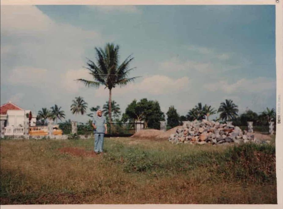 Foto arsip tahun 1993: pendiri berdiri di lahan yang kelak menjadi pesantren, di samping tumpukan batu pondasi